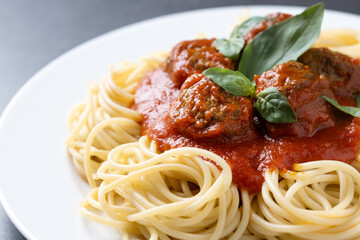 Spaghetti with meatballs isolated on black background. Close up