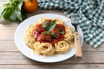 Spaghetti with meatballs on wooden table