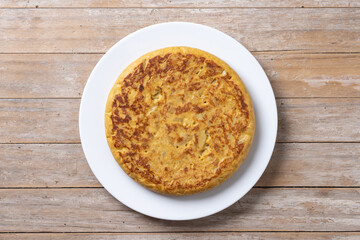 Traditional spanish omelette on wooden table. Top view