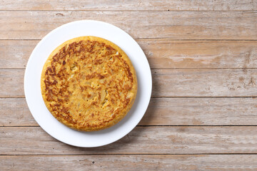 Traditional spanish omelette on wooden table. Top view. Copy space