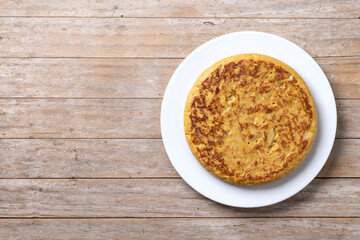Traditional spanish omelette on wooden table. Top view. Copy space