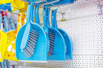 blue dustpan and broom sets for cleaning in a supermarket display case