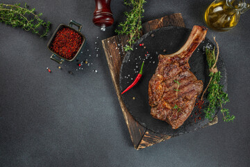 rib eye Tomahawk beef veal steak on a dark background. top view. copy space for text