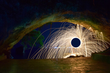 Steel wool photography during night inside cave, taken using long exposure