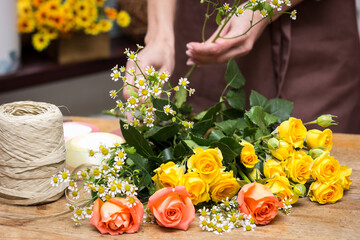 Girl florist makes bouquet.Flowers close-up the hands of florist.Florist cuts rose flowers with secateurs.pruning stems with secateurs.girl cut flowers with secateurs close-up. floristry courses. - Powered by Adobe