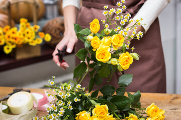 Girl florist makes bouquet.Flowers close-up the hands of florist.Florist cuts rose flowers with secateurs.pruning stems with secateurs.girl cut flowers with secateurs close-up. floristry courses.