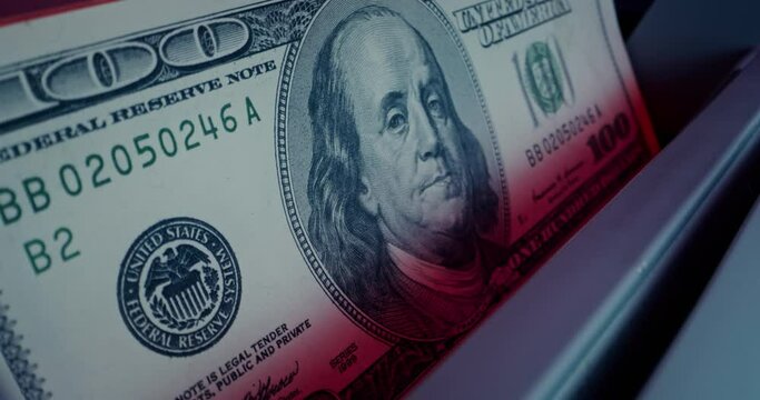 The calculating machine counts a stack of dollar bills, close-up