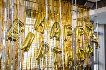 Birthday party. Happy birthday, text. Arch decorated with golden balloons. Photo-wall decoration...