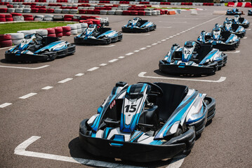 Car kart crossing the line. Many racing cars are ready to race on the track. Machine kart before the start. Go kart speed rive outdoor race, opposition race.