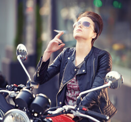 Fototapeta na wymiar Woman, leather and cigarette in city with motorcycle for travel, transport or road trip as rebel. Fashion, street and person smoking nicotine with attitude on classic or vintage bike for journey