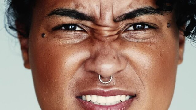 Upset Young woman reacts with intense negative reaction frowning in anger looking directly at camera grimacing and feeling upset, close-up face
