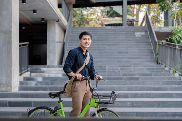 Fototapeta na wymiar Eco friendly, Happy lifestyle asian young businessman ride bicycle go to office work at city street with bicycle in morning