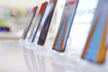 A lot of smartphone models on display at the exhibition stand of an electronics store