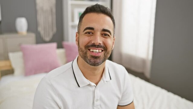 Handsome young hispanic man confidently blowing a love-filled kiss at the camera. sitting in his bedroom, this adorable guy's happy expression just radiates fun and sexiness.