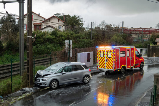 Carro acidentado contra um poste num dia frio e gelado de inverno e uma ambul&acirc;ncia no resgate dos feridos