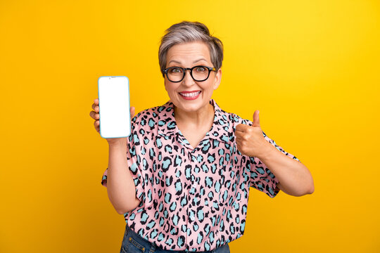 Photo portrait of lovely senior lady white screen show thumb up dressed stylish leopard print garment isolated on yellow color background