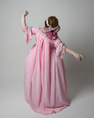 Full length portrait of woman wearing historical French baroque pink gown in style of Marie...