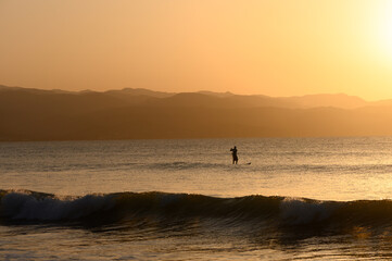 SUP boarding lesson on the Mediterranean sea in winter at sunset 3