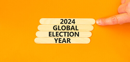 2024 global election year symbol. Concept words 2024 global election year on wooden stick. Beautiful orange table orange background. Voter hand. Business 2024 global election year concept. Copy space.