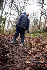 View of a Child in the woods looking up. Low angle view.