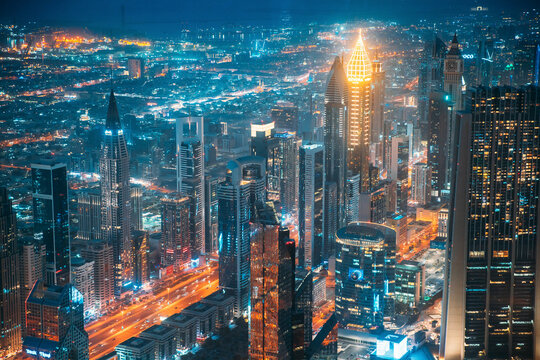 Dubai, UAE, United Arab Emirates - May 25, 2021: Aerial View Of City Background Of Illuminated Cityscape With Skyscrapers And Modern Urban Architecture In Dubai Resort Town. Street Night Traffic In
