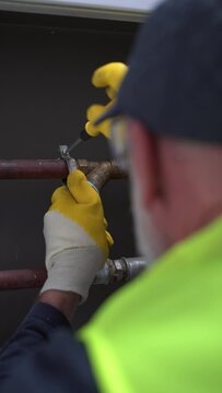 Handyman Worker Screwing Up Pipe Installation Wearing Protective Gear, Vertical Video