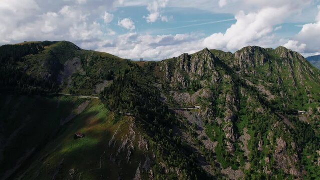 Aerial drone footage of the SP232 road, Panoramica Zegna in Piedmont with a view of the Alps. Dolly out camera movement, no one inside