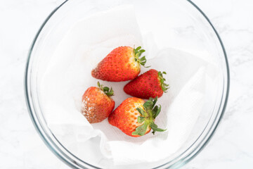 Fresh and Moldy Strawberries in a Glass Bowl on a White Napkin