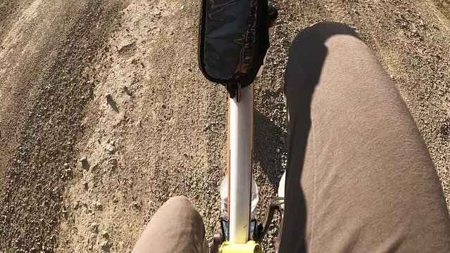  Bicycle drive point view. Girl driving bice on rocky road․ Bike on off road.