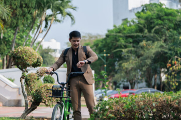 Fototapeta na wymiar Young businessman in suit in city park bike to work eco friendly alternative vehicle green energy