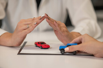 Obraz na płótnie Canvas Close-up of woman's hands and car insurance agent. 