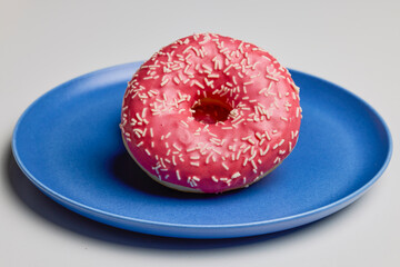 donuts with pink frosting on a plate.