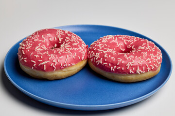 donuts with pink frosting on a plate.