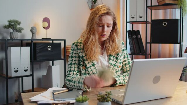 Caucasian young woman freelancer counting cash insufficient amount of money. Financial crisis. Bankruptcy. Poverty and destitution. Female girl businesswoman with laptop sitting at home office table.