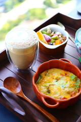 Hearty breakfast, latte and cereal bowls, cheese baked eggs