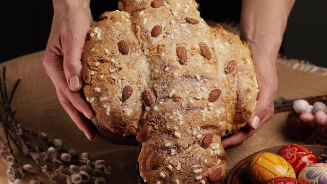 COLOMBA cake is a traditional Italian Easter dessert. Easter cake dove in women's hands close-up