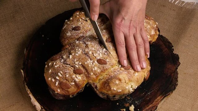 COLOMBA cake is a traditional Italian Easter dessert. The chef cuts the Easter colomba cake and demonstrates the delicate and airy pastry. Top view