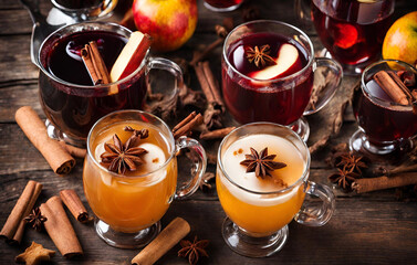 Christmas mulled wine with apple, cranberry, orange, spices and chocolate on a wooden table
