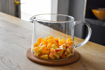Glass kettle for hot tea with sliced apple and orange