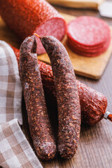 Smoked salami sausages on wooden table.