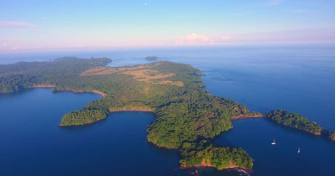 Drone video overlooking the beautiful Parida Islands in Panama with colorful clouds looming over the horizon off in the distance at sunrise