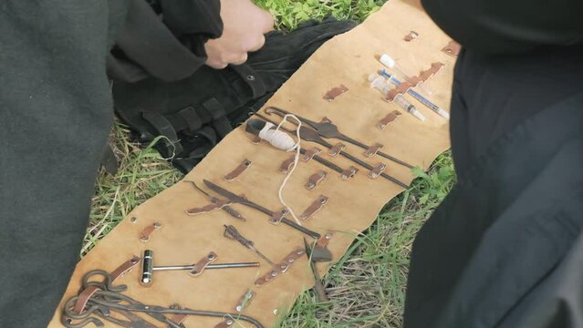 LARP (live action role play) scene: a doctor showing a collection of tools from a portable surgical kit. Detail shot, slow motion.