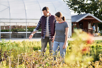 Worker advising the client over plants in garden center