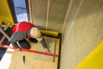 Fototapeta na wymiar Contractor Cutting to Size Mineral Wool Insulation Material