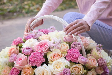 Girl florist holding a basket of flowers in her hands