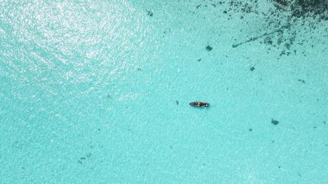 Paddle boarding in blue ocean, aerial view. Transparent sea in Maldives