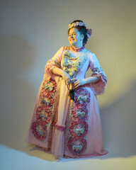 cinematic  portrait of female model wearing an opulent pink gown,  costume of a historical French baroque nobility, style of Marie Antoinette. Holding ring of keys,  Isolated on  studio background