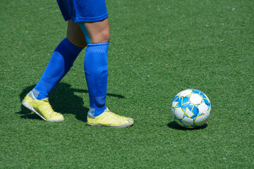 Girl football player attacking legs kicking soccer ball