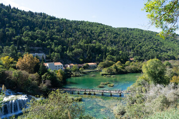 Fototapeta na wymiar Krka National Park, Split, Croatia. Waterfall surrounded by green landscape and forest. Located in the region of Dalmatia. 