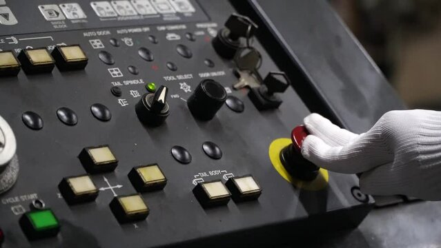 factory worker quickly pushing red button to emergency turn off the machine.concept of prevention before damage of CNC machines